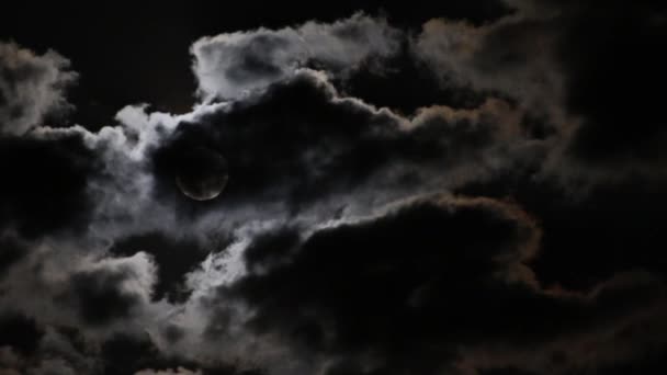 Volle maan in de flarden van donkere wolken verdwijnen — Stockvideo