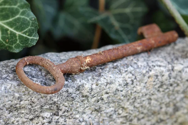 La vieja llave oxidada perdida yaciendo en la piedra - profundidad superficial del campo —  Fotos de Stock