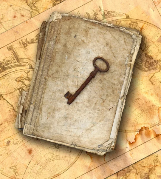 Usado e esfarrapado livro e velha chave enferrujada nos mapas antigos — Fotografia de Stock