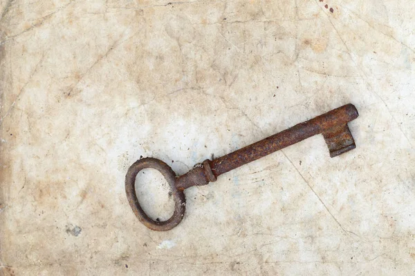 Ржавый ключ на старом пергаменте — стоковое фото
