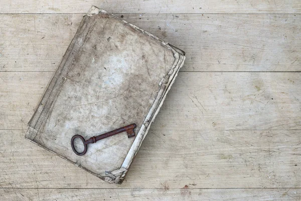 Rusty key on the old tattered book — Stock Photo, Image