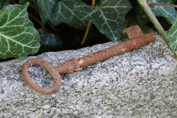 Потерянный старый ржавый ключ лежит на камне — стоковое фото