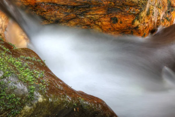 Detalhe abstrato da água corrente entre os pedregulhos — Fotografia de Stock
