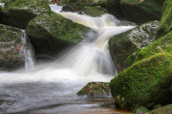 Stroom van water door rotsen bedekt met mos — Stockfoto