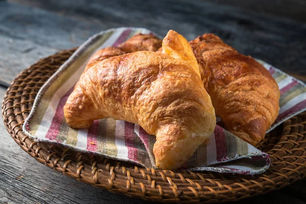 Warm croissants on wicker plate — Stock Photo, Image
