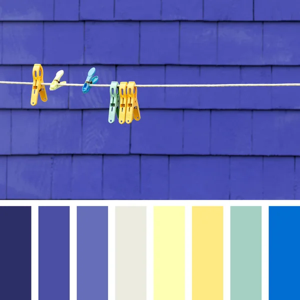 Washing line with colourful clothes pegs, against a purple wood shingle wall. Set in a colour palette with complimentary colour swatches.