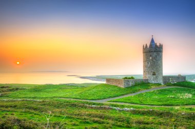 Beautiful irish castle near Atlantic ocean at sunset clipart