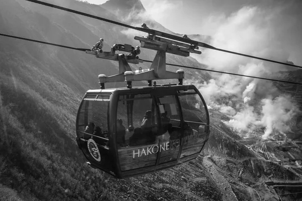 People traveling by aerial ropeway lift over volcanic valley of Owakudani — Stock Photo, Image