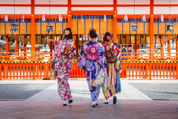 ผู้หญิงสาวสวมชุดกิโมโนญี่ปุ่นแบบดั้งเดิมที่ศาลเจ้าฟูชิมิอินาริในเกียวโต — ภาพถ่ายสต็อก