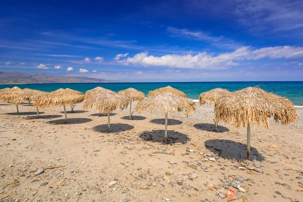 Guarda-sóis tropicais na praia de Maleme em Creta — Fotografia de Stock