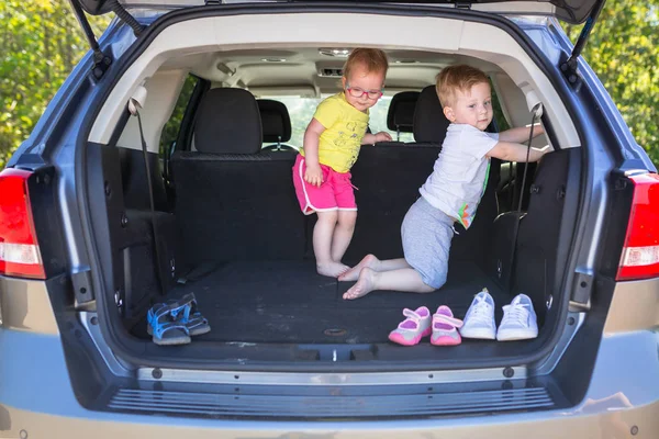 ΕΥΤΥΧΙΣΜΕΝΟ twins παίζοντας στο αυτοκίνητο — Φωτογραφία Αρχείου