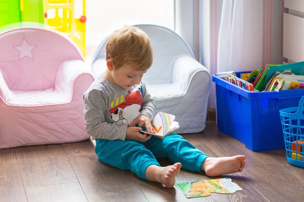 Küçük çocuk kitap okuyor. 