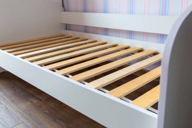 Assembling wooden bed in childrens room clipart