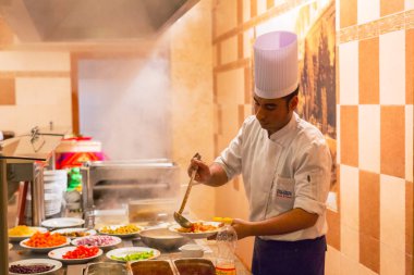 Hurghada, Mısır - 9 Nisan 2013: aşçı yemek üç köşe Sunny Beach Otel'de Hurghada hizmet. Üç köşe olduğunu Belçika şirketi ile Mısır'daki kızıl denizde 11 otel ve bir Budapeşte, Macaristan.
