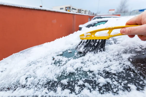 車の窓から凍りついた雪を削り — ストック写真