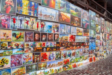 KRAKOW, POLAND - JUNE 28, 2013: Oil paints gallery on the city walls of Krakow old town, Poland. This famous street gallery is located on the city walls at St. Florian Gate, the focal point of Krakow. clipart