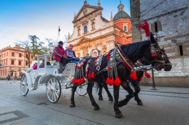 Krakow, Polonya - 12 Kasım 2017: Polonya 'nın Krakow kentindeki ana meydanda at arabaları. Krakow Polonya 'nın ikinci büyük ve en eski şehirlerinden biridir..