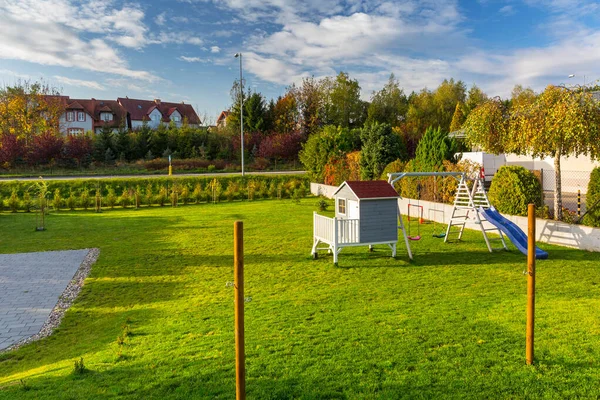 秋に子供や遊び場のための美しい木造の家を持つ緑の庭 — ストック写真