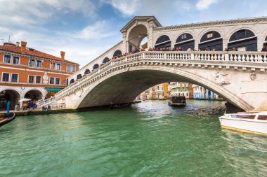 Venedik, İtalya - 24 Ekim 2019: Ponte di Rialto köprüsü Venedik Büyük Kanalı üzerinde geleneksel tekne ve renkli mimari ile, İtalya