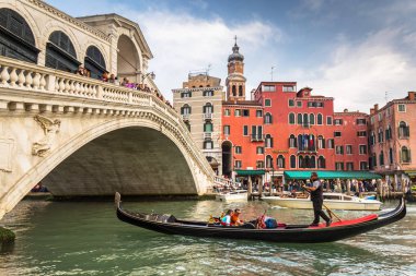 Venedik, İtalya - 24 Ekim 2019: Ponte di Rialto köprüsü Venedik Büyük Kanalı üzerinde geleneksel tekne ve renkli mimari ile, İtalya