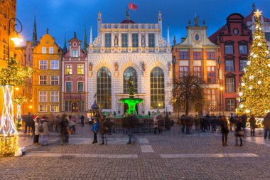 Gdansk 'ta uzun bir patika ve Polonya' da alacakaranlıkta güzel bir Noel ağacı.