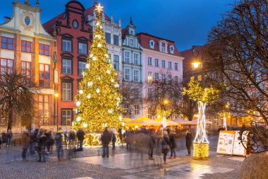 Gdansk 'ta uzun bir patika ve Polonya' da alacakaranlıkta güzel bir Noel ağacı.