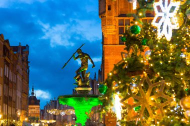 Gdansk 'taki Long Lane ve Neptün çeşmesi. Alacakaranlıkta güzel bir Noel ağacı, Polonya.