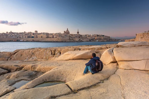 Muž Sedící Skále Sledující Krásnou Architekturu Města Valletta Úsvitu Malta — Stock fotografie