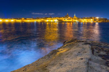 Malta kıyıları ve gece Valletta şehrinin mimarisi.