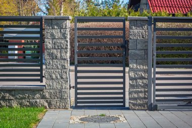Stone fence and entrance gate with remote control clipart