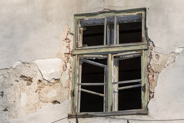 Разбитое окно на серой стене — стоковое фото