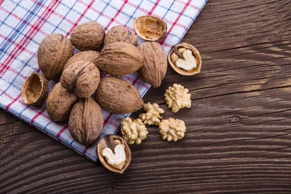 Kernel kenari dan seluruh kacang kenari di meja kayu tua — Stok Foto