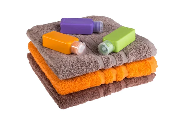 Colorful towels and small plastic bottles for travel on a white — Stock Photo, Image