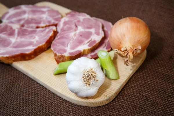 Primo piano di un tagliere con carne di maiale affumicata — Foto Stock