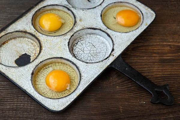 Chicken eggs in a frying pan. Rustic style. — Stock Photo, Image