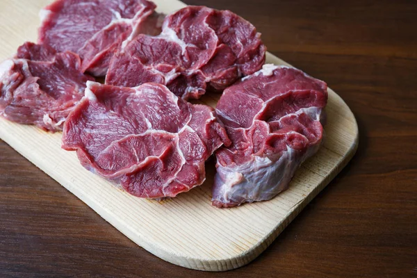 Carne crua fresca em chapa de corte de madeira — Fotografia de Stock