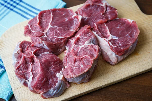 Carne crua fresca em chapa de corte de madeira — Fotografia de Stock