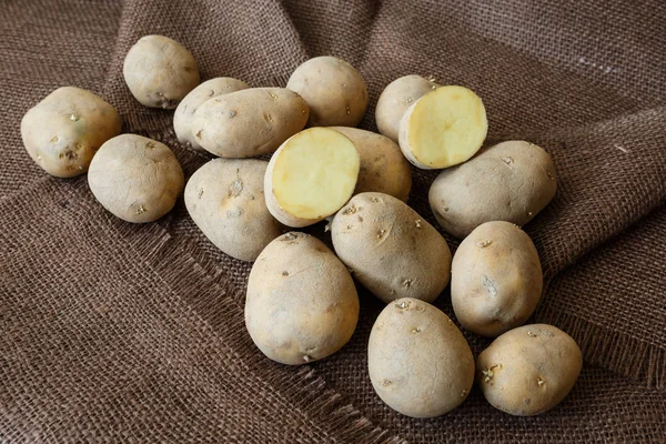 Batata velha com brotos jovens em uma mesa de madeira — Fotografia de Stock