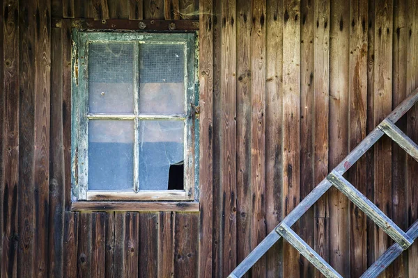 Oude gebroken raam in de houten muur van het huis en de oude houten — Stockfoto
