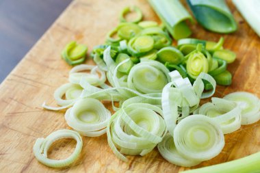Taze pırasa ahşap tahta üzerinde küçük parçalar halinde kesilmiş