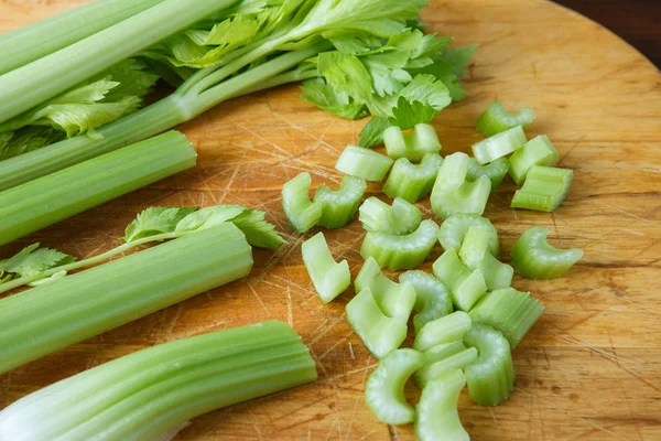 Celery chopped on wooden cutting board — Stock Photo, Image