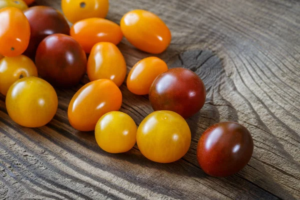 Tomates cereja no fundo de madeira rústica — Fotografia de Stock