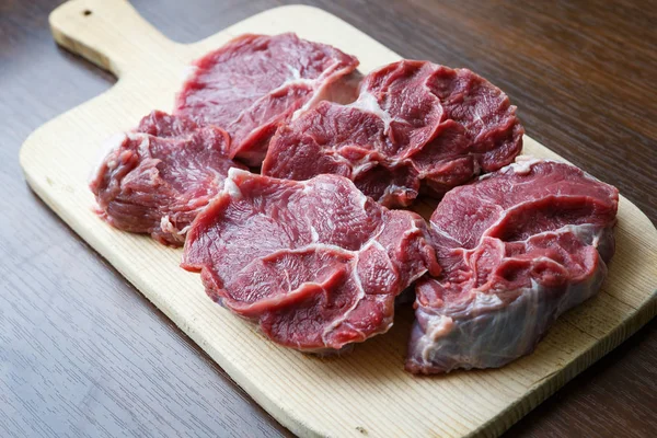 Carne crua fresca em chapa de corte de madeira — Fotografia de Stock