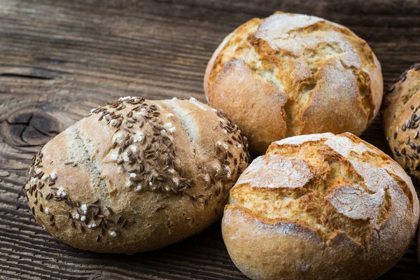 Diferentes tipos de pão fresco na mesa de madeira. — Fotografia de Stock