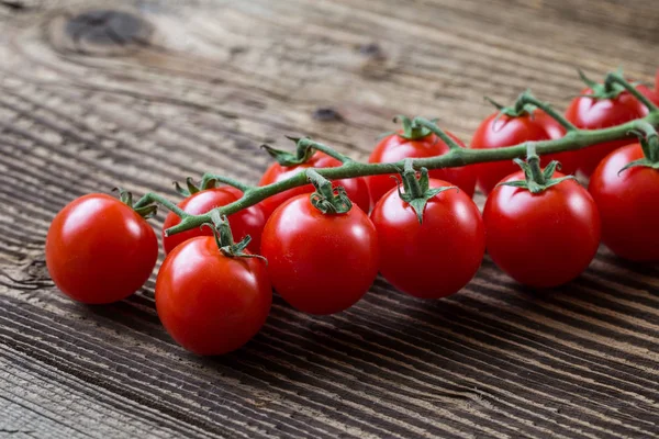 Fresh cherry tomatoes on a brown background.