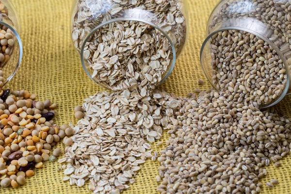 Glazen potten met diverse peulvruchten - bonen, havermout vlokken — Stockfoto