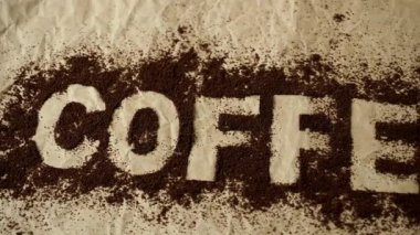 Kahve kelime üstünde-e doğru toz kahve yazılı. Kahverengi bir arka plan üzerinde kelime 