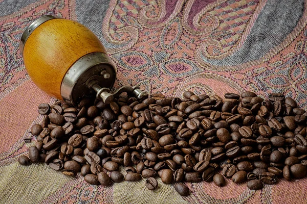 Geröstete Kaffeebohnen auf buntem Tuch auf dem Tisch. — Stockfoto