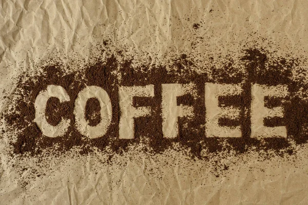 Kaffeewort auf Kaffeepulver geschrieben — Stockfoto