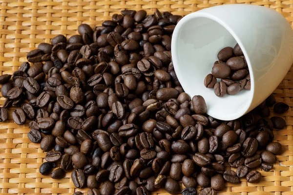 Geröstete Kaffeebohnen im weißen Becher auf dem Tisch — Stockfoto